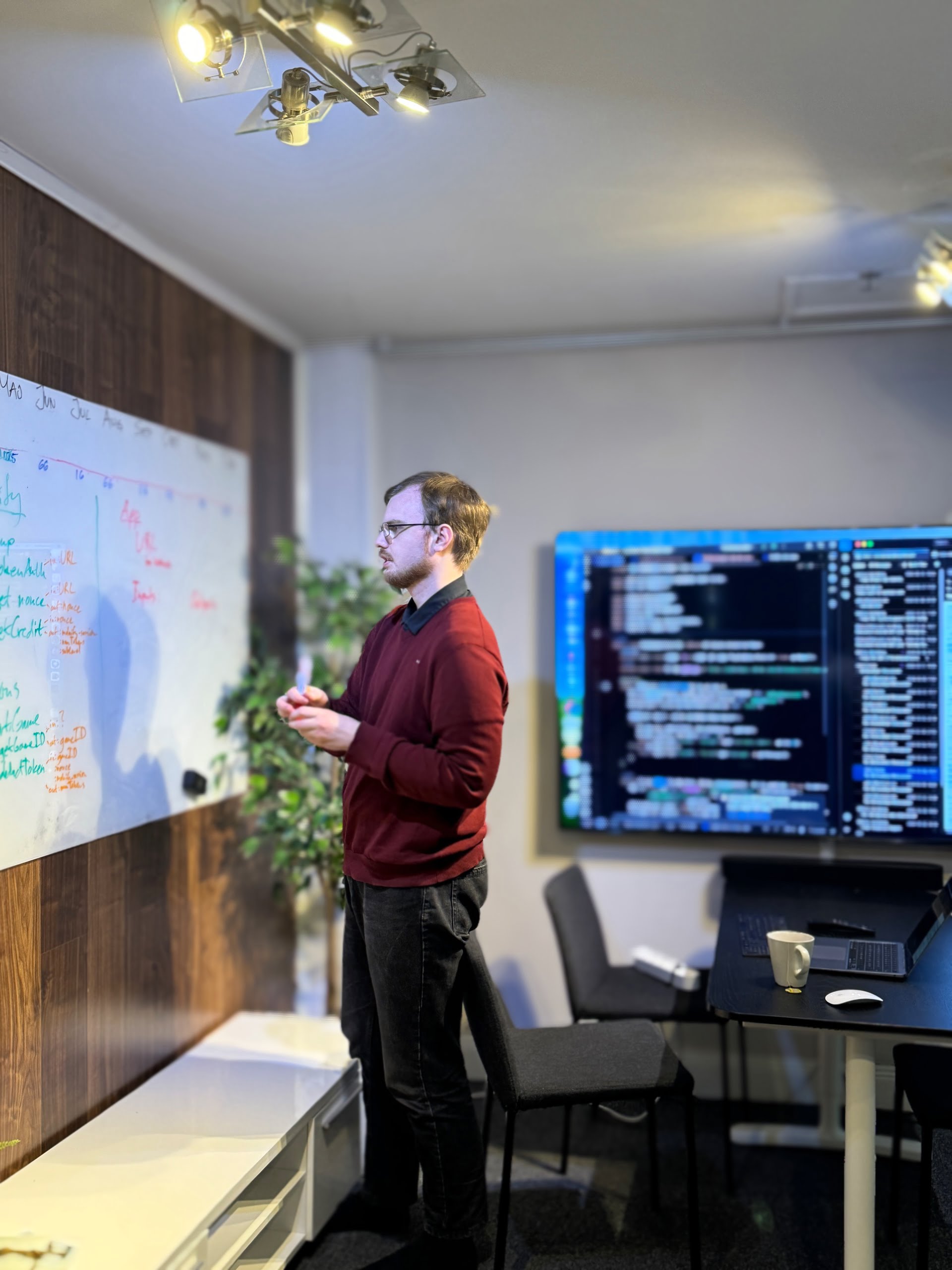 Erik is standing in the office in front of a blackboard and writing